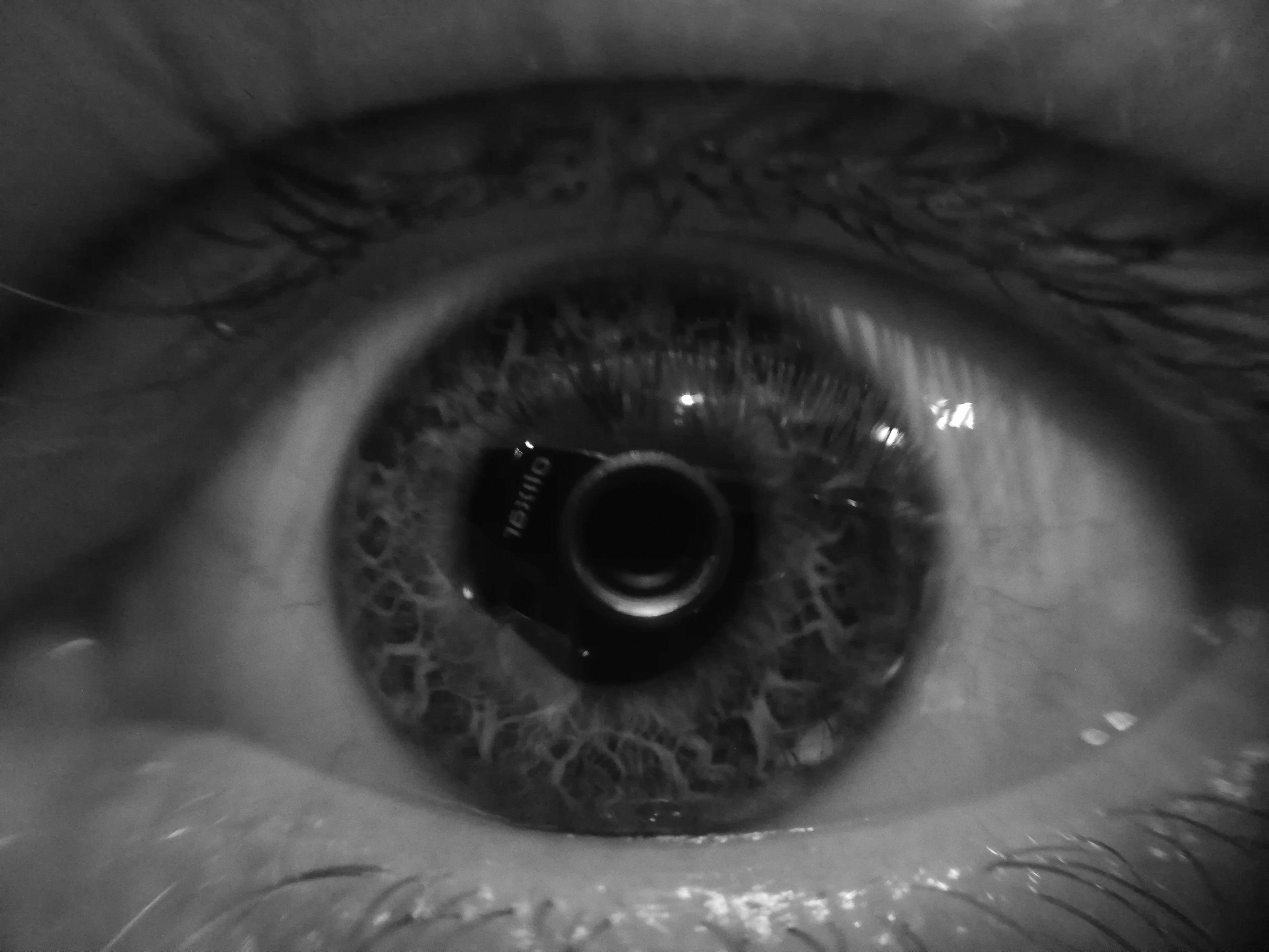 A black and white shot of my camera lens reflecting off of my eye